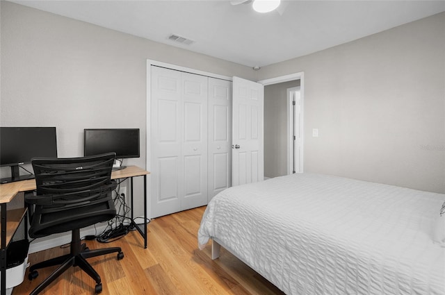 bedroom featuring ceiling fan, a closet, and light hardwood / wood-style flooring