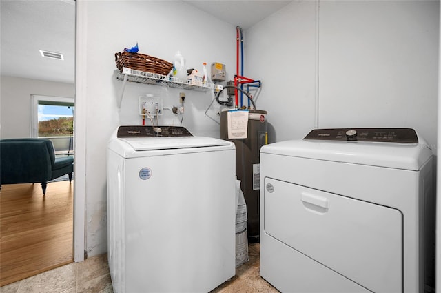 laundry area featuring electric water heater and independent washer and dryer