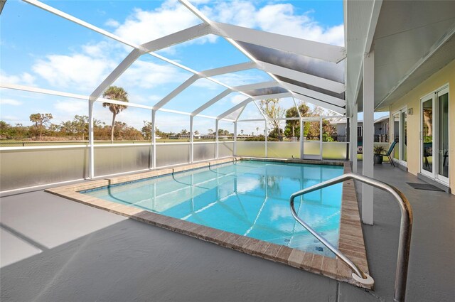 view of swimming pool featuring glass enclosure and a patio