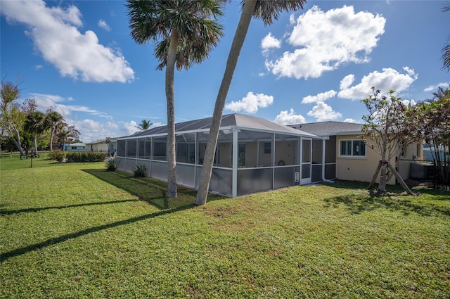 back of property featuring a lanai and a yard