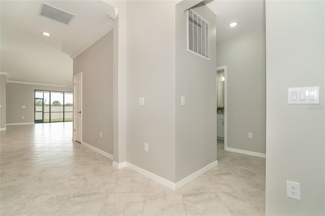 hall with a high ceiling and crown molding