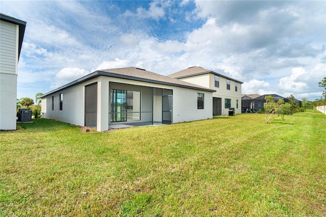 rear view of house with cooling unit, a lawn, and stucco siding