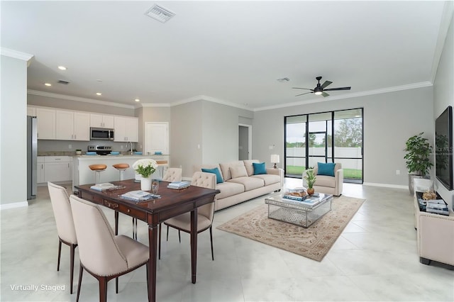 interior space featuring visible vents, baseboards, ornamental molding, and a ceiling fan