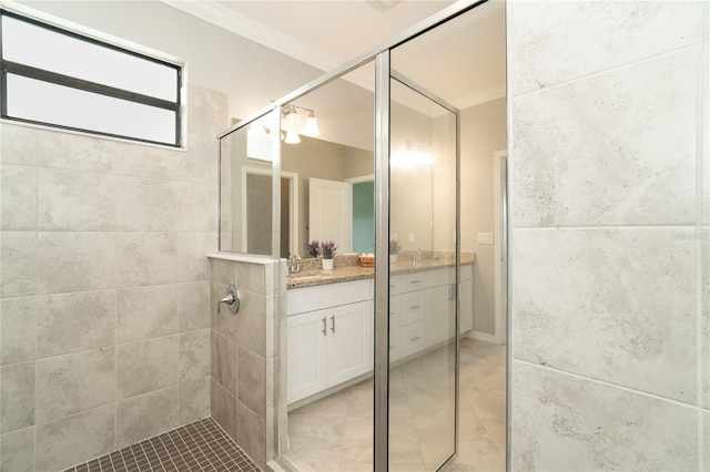 bathroom featuring tile patterned floors, vanity, a shower stall, and crown molding