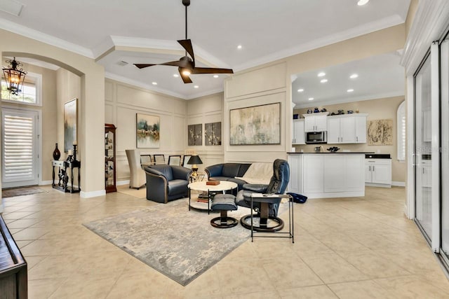 tiled living room with ornamental molding and ceiling fan