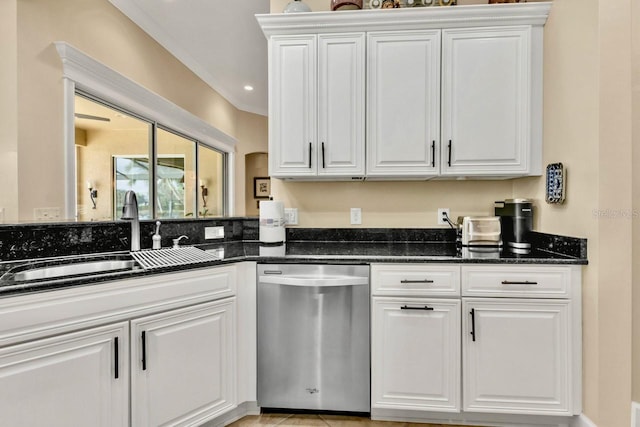 kitchen featuring dishwasher, sink, dark stone countertops, and white cabinets