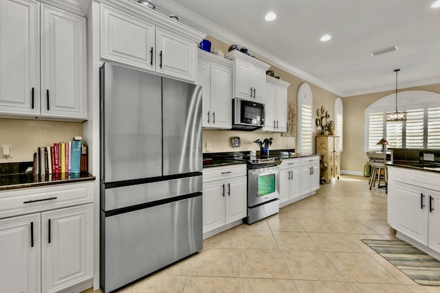 kitchen featuring ornamental molding, stainless steel appliances, white cabinetry, light tile patterned floors, and a chandelier