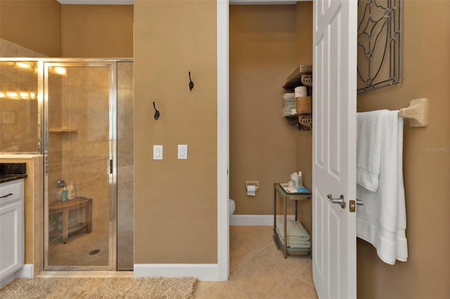 bathroom featuring a shower with shower door, tile patterned flooring, and toilet