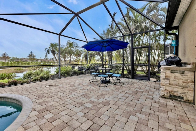 view of patio featuring glass enclosure and a water view