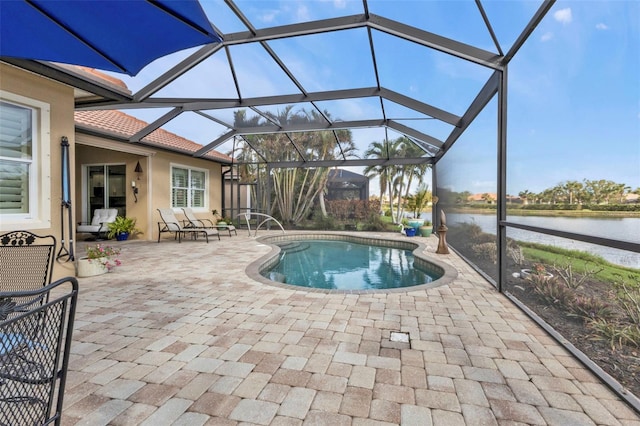 view of swimming pool with a water view, glass enclosure, and a patio area