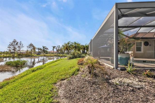 view of yard featuring glass enclosure and a water view