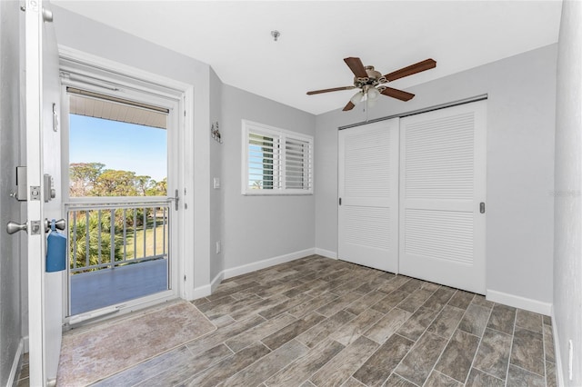 unfurnished bedroom featuring hardwood / wood-style floors, ceiling fan, multiple windows, and a closet