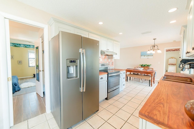 kitchen with stainless steel appliances, sink, white cabinets, light tile patterned flooring, and pendant lighting