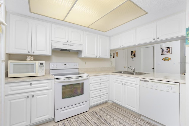 kitchen with white cabinetry, white appliances, sink, and kitchen peninsula