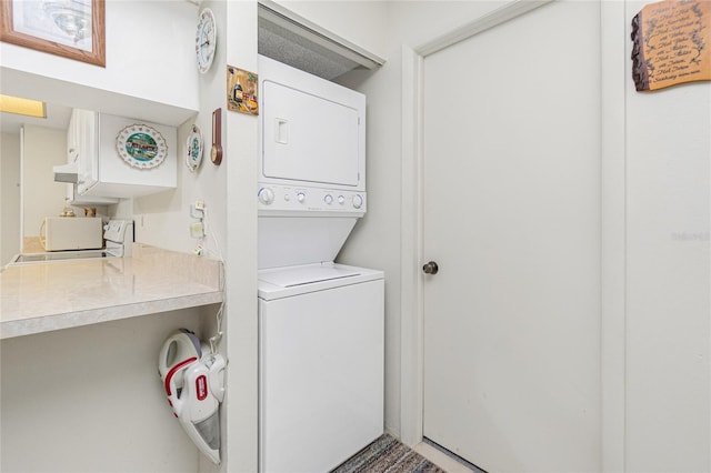 washroom featuring stacked washer and clothes dryer