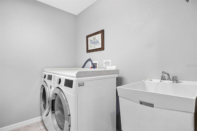 washroom featuring sink, light tile patterned floors, and washer and dryer