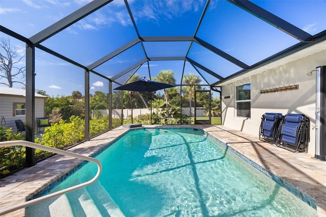 view of pool featuring glass enclosure and a patio area