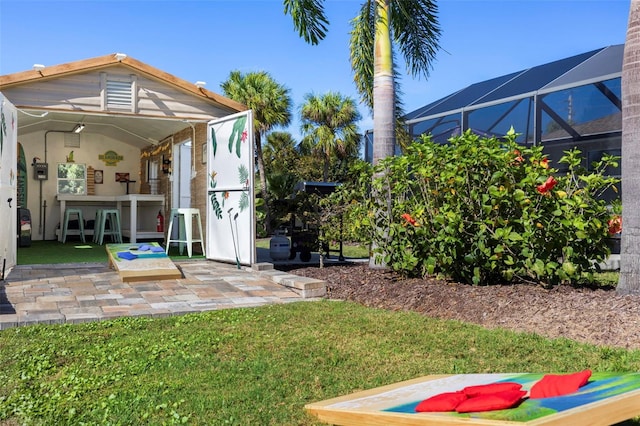 view of yard featuring glass enclosure, a patio area, and an outdoor bar