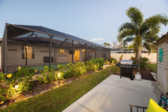 view of patio featuring glass enclosure and area for grilling