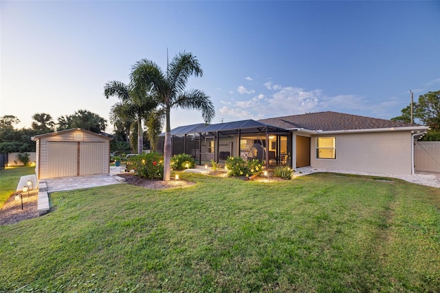 view of front of property with an outbuilding, glass enclosure, and a lawn