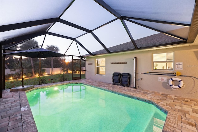 view of swimming pool featuring glass enclosure and a patio