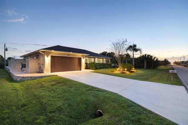 view of front of home featuring a lawn and a garage