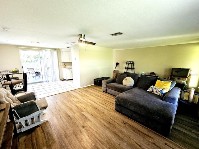 living room with light hardwood / wood-style flooring and ceiling fan