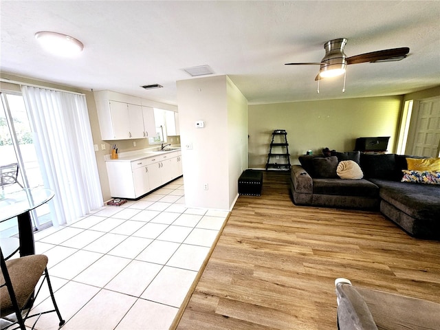 living room with light hardwood / wood-style floors, ceiling fan, a textured ceiling, and sink