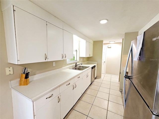 kitchen with white cabinets, light tile patterned flooring, sink, and appliances with stainless steel finishes