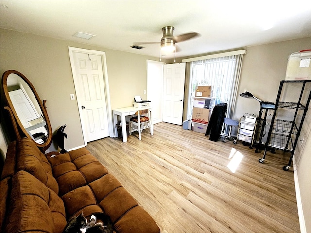 living room featuring light wood-type flooring and ceiling fan