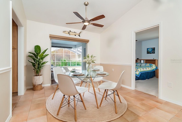 tiled dining space with ceiling fan and lofted ceiling