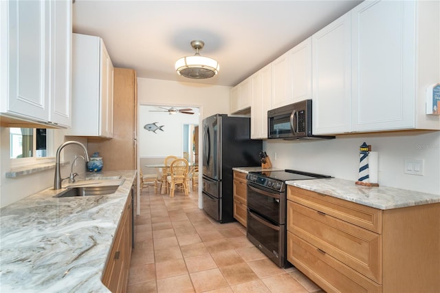 kitchen featuring stainless steel appliances, white cabinetry, sink, and light stone counters