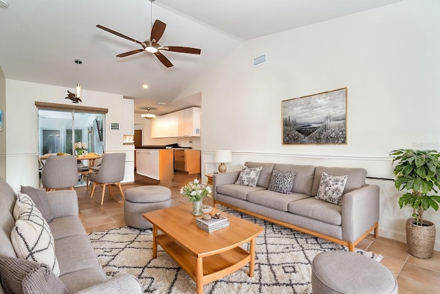 living room with light tile patterned floors, ceiling fan, and vaulted ceiling