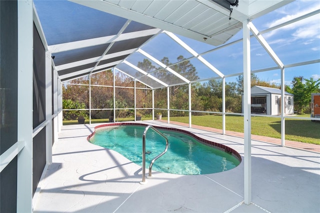 view of pool with a yard, a patio, and glass enclosure