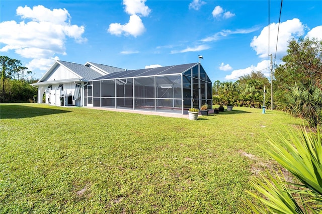 rear view of property with a lawn, central AC, and glass enclosure