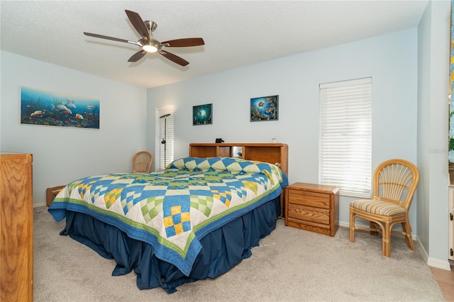 carpeted bedroom featuring a textured ceiling and ceiling fan