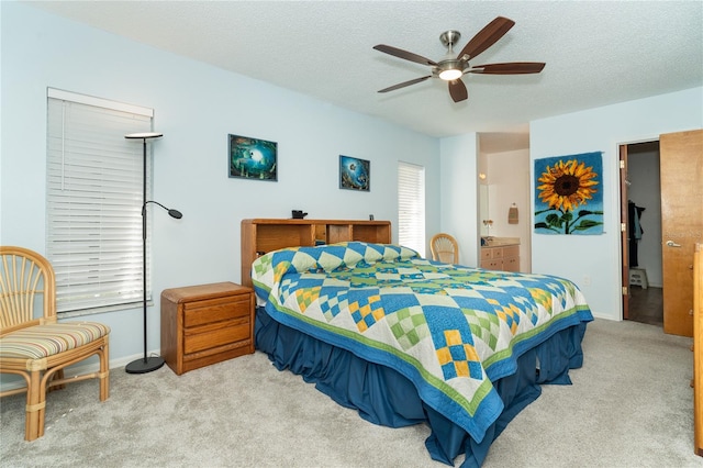 carpeted bedroom featuring ceiling fan and a textured ceiling