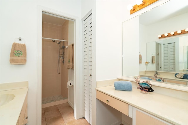 bathroom featuring tile patterned flooring, vanity, and a tile shower