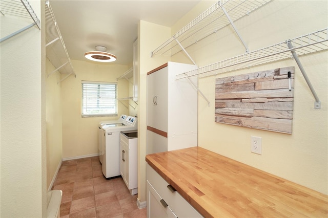 clothes washing area featuring cabinets and washer and clothes dryer