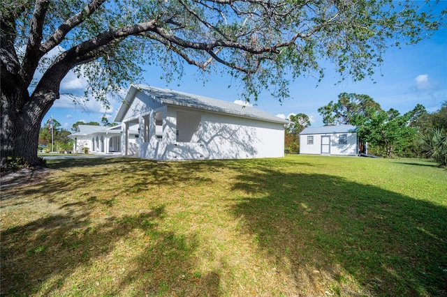 rear view of property with a lawn and an outdoor structure