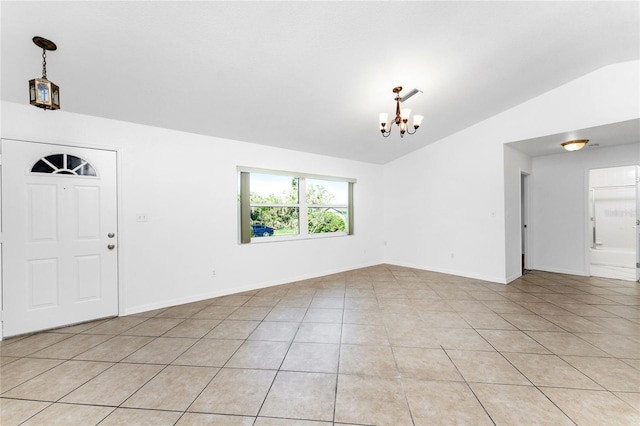 tiled entrance foyer featuring lofted ceiling and a notable chandelier