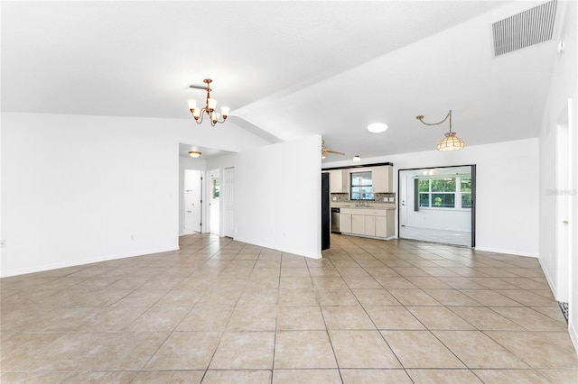 unfurnished living room with light tile patterned flooring, vaulted ceiling, and an inviting chandelier