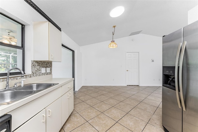 kitchen featuring white cabinets, stainless steel refrigerator with ice dispenser, vaulted ceiling, and pendant lighting
