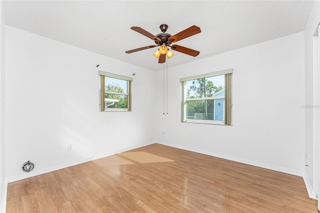 spare room with plenty of natural light, ceiling fan, and light hardwood / wood-style flooring