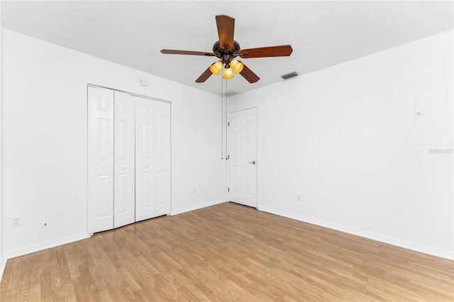 unfurnished bedroom featuring a closet, light hardwood / wood-style floors, and ceiling fan