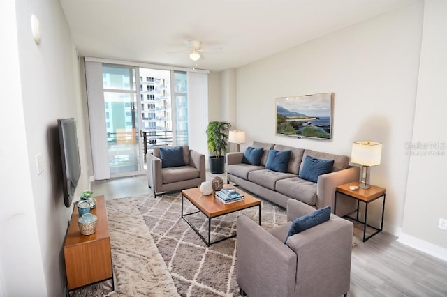 living room with hardwood / wood-style flooring, floor to ceiling windows, and ceiling fan