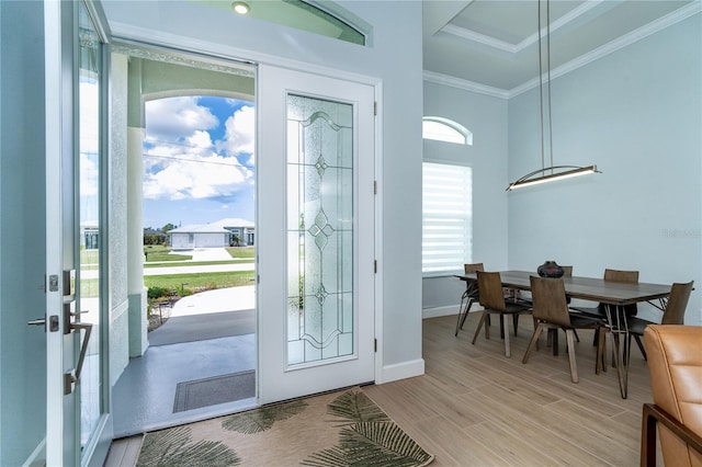 entrance foyer with ornamental molding and light hardwood / wood-style floors