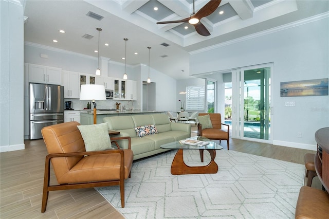 living room featuring light hardwood / wood-style flooring, a high ceiling, coffered ceiling, ornamental molding, and beamed ceiling