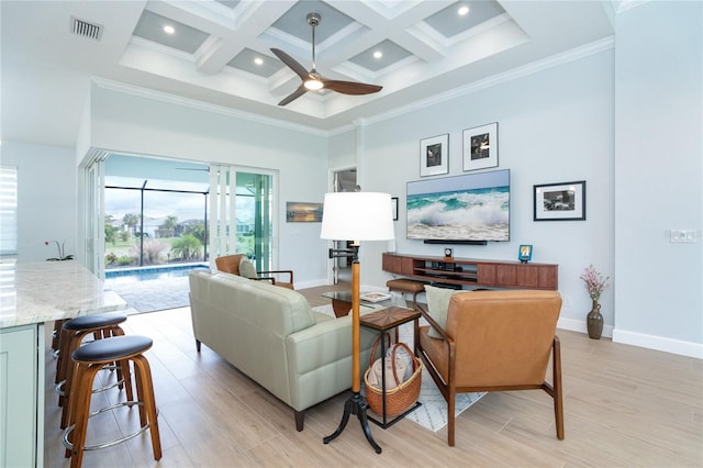 living room with ceiling fan, a towering ceiling, coffered ceiling, light hardwood / wood-style floors, and beamed ceiling