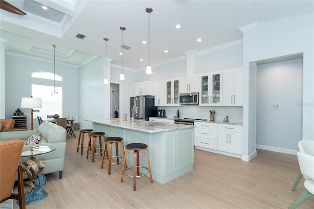 kitchen with stainless steel appliances, white cabinetry, and pendant lighting